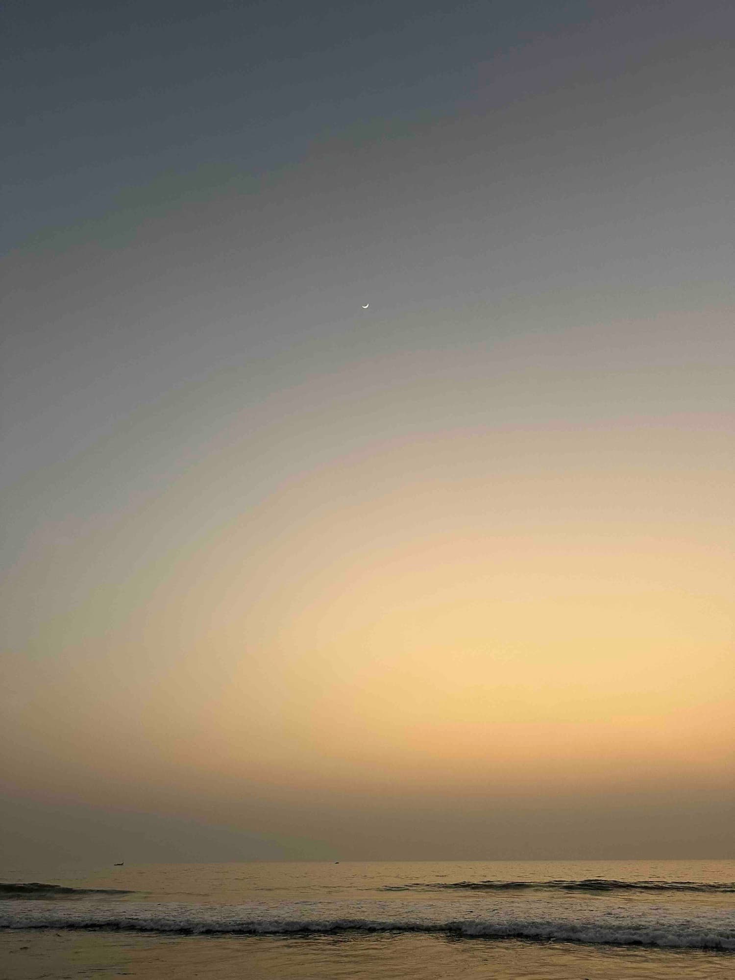 The horizon glow intensifies as the moon holds steady above